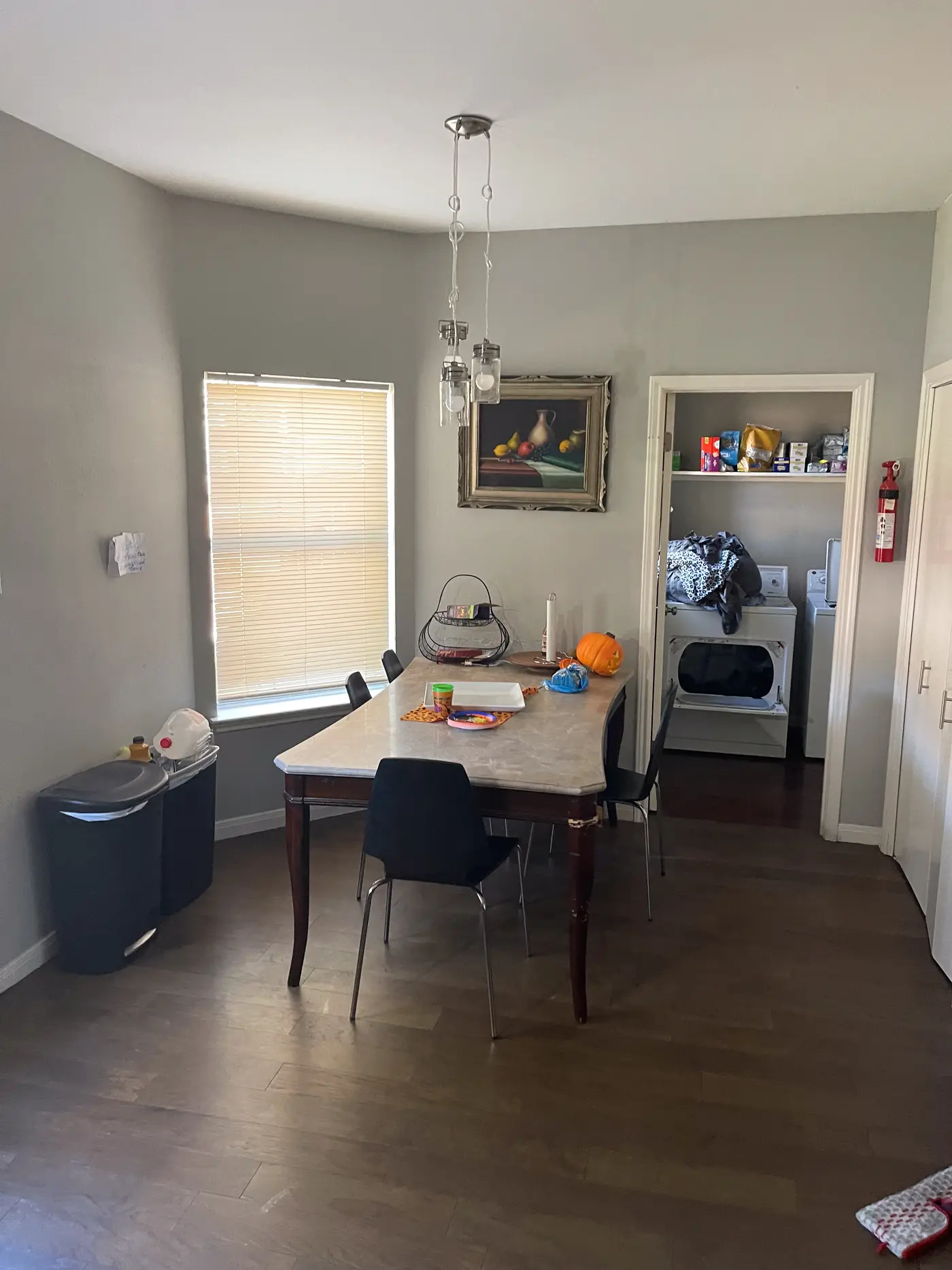 Dining nook with a round table by the window and the laundry beyond.