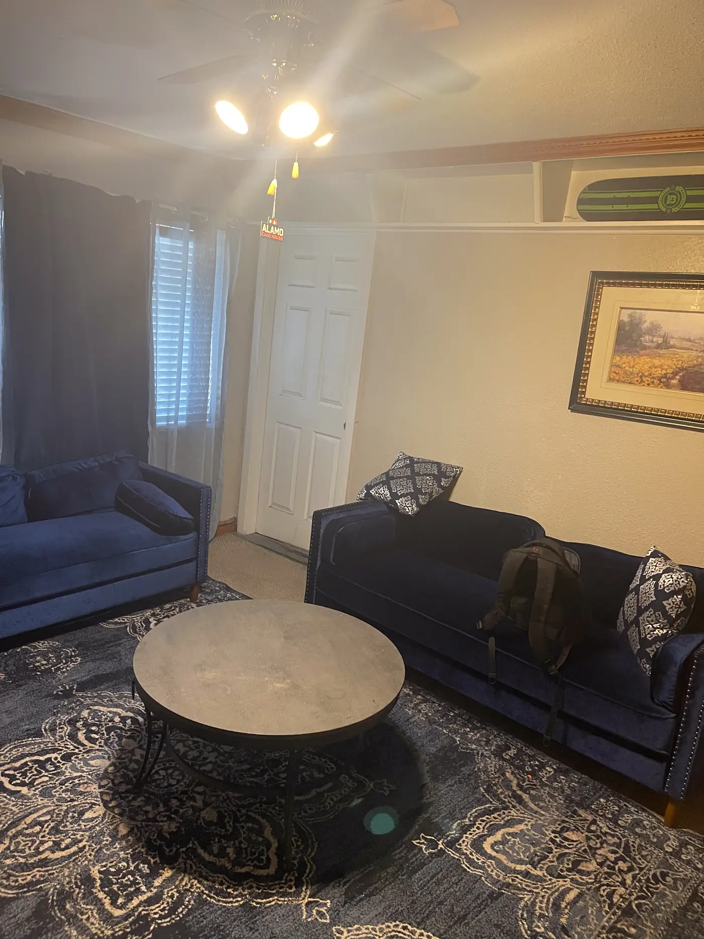 Living room with a navy sofa, round table and a patterned rug.