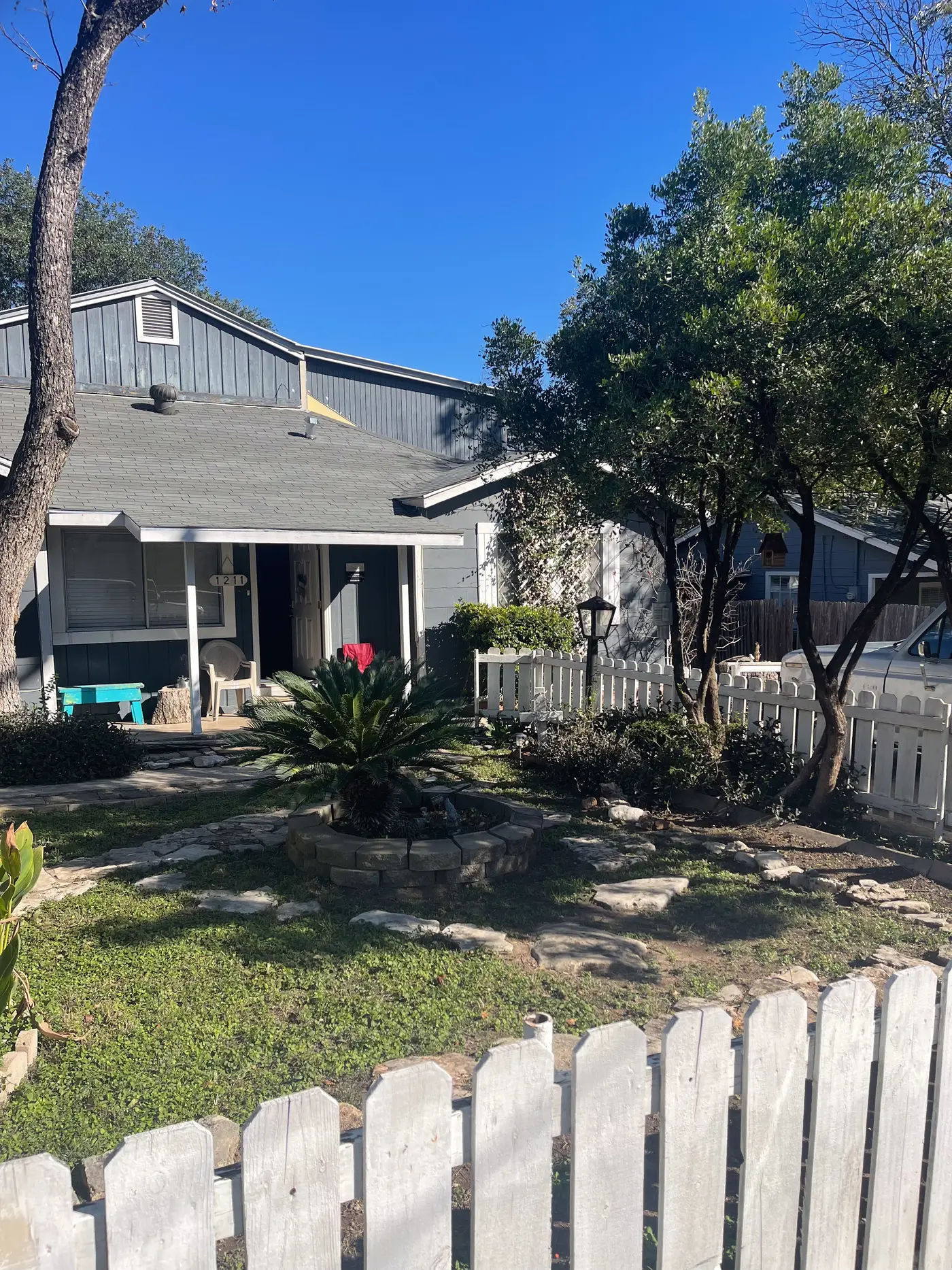 Front yard with the house and mature trees beyond.