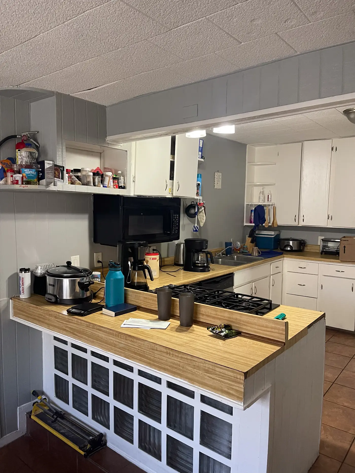 Kitchen with an island, open shelving and a stainless range.