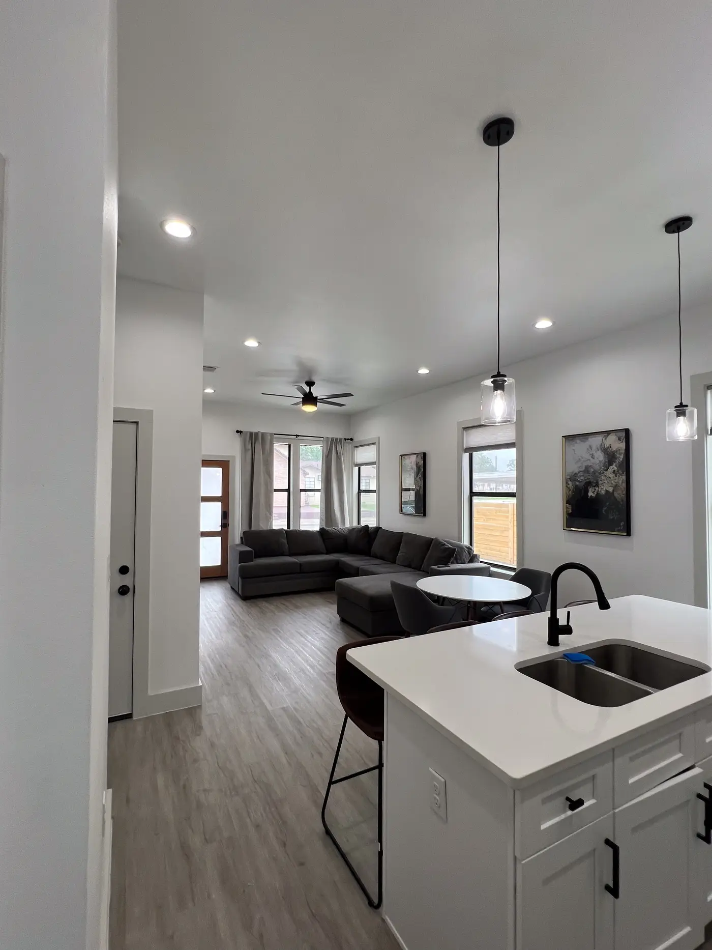 Open-plan kitchen with a quartz island and undermount sink, looking through to the living area.