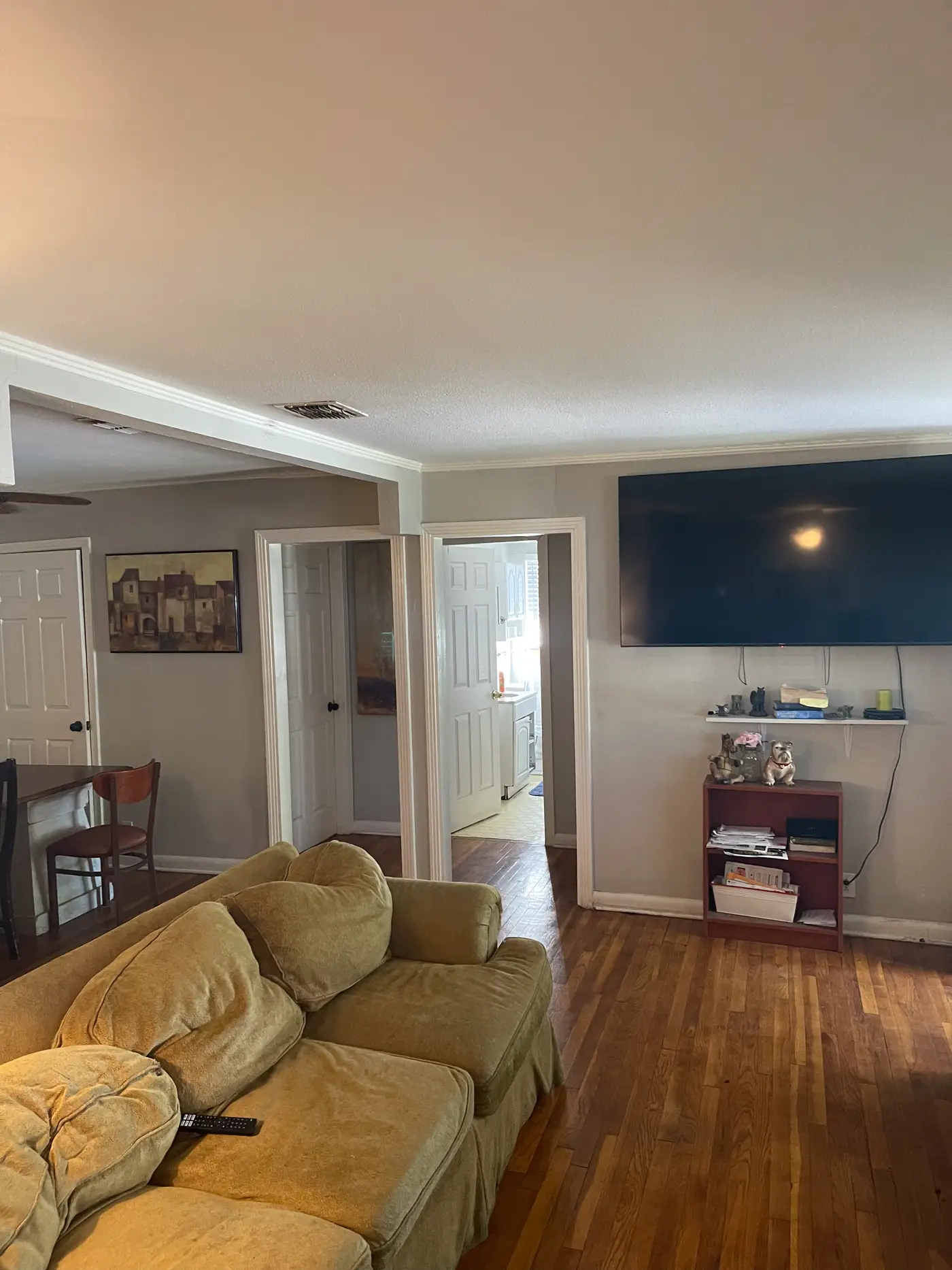 Living room with a wall-mounted television and armchairs.
