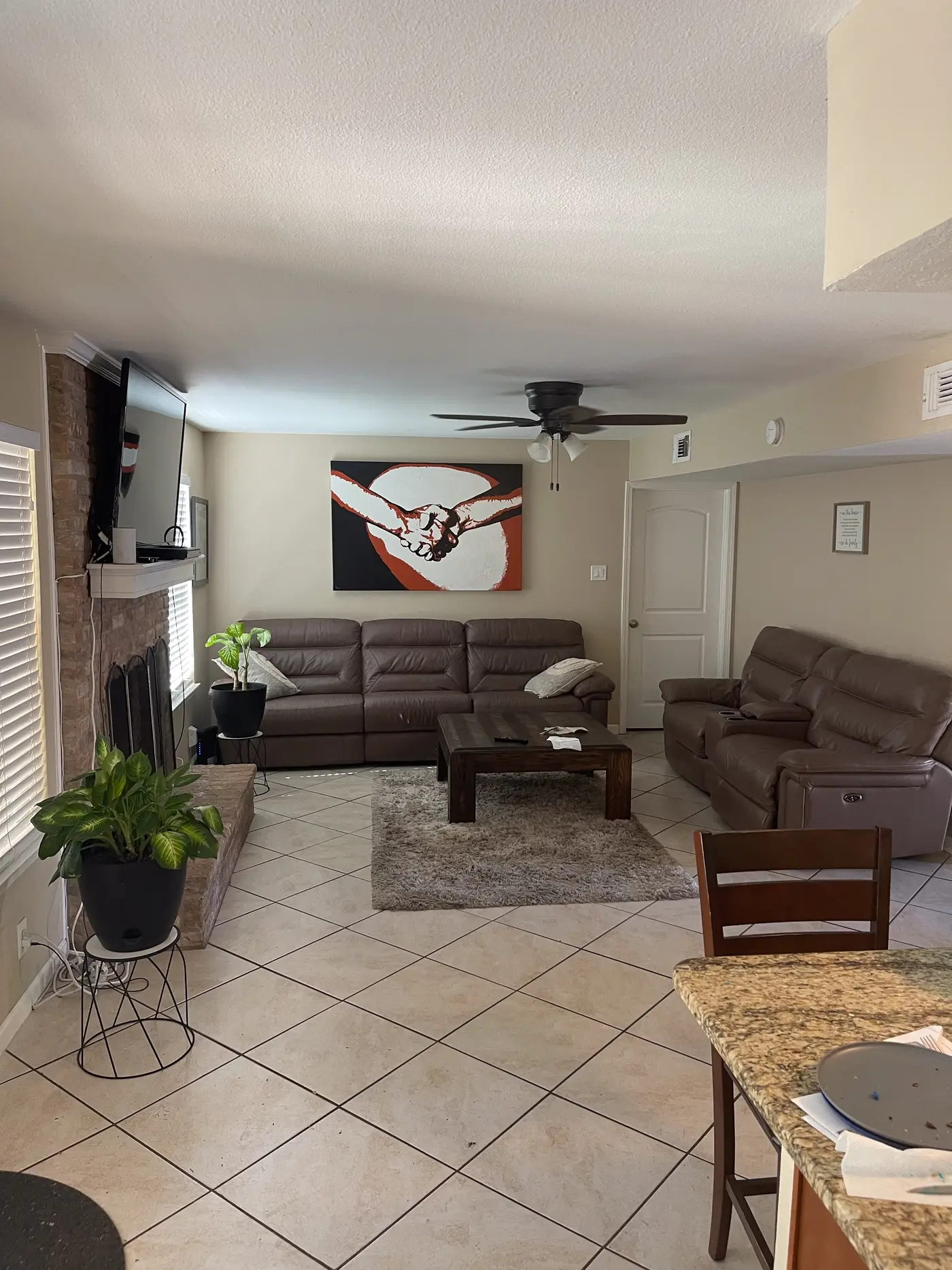 Living room with leather sofas and a stone fireplace.