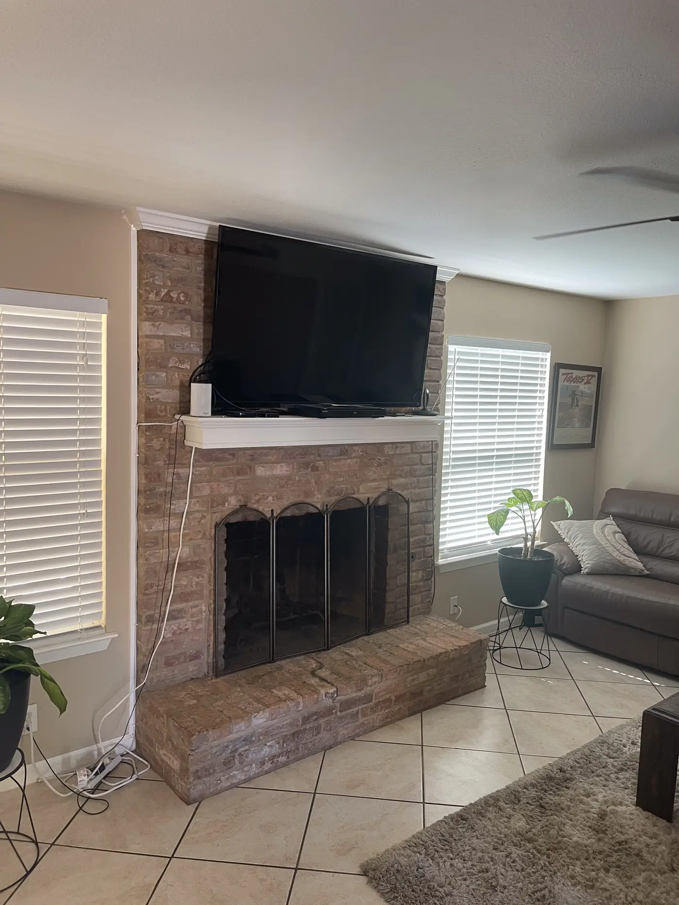 Living room with a stone fireplace and a wall-mounted television.
