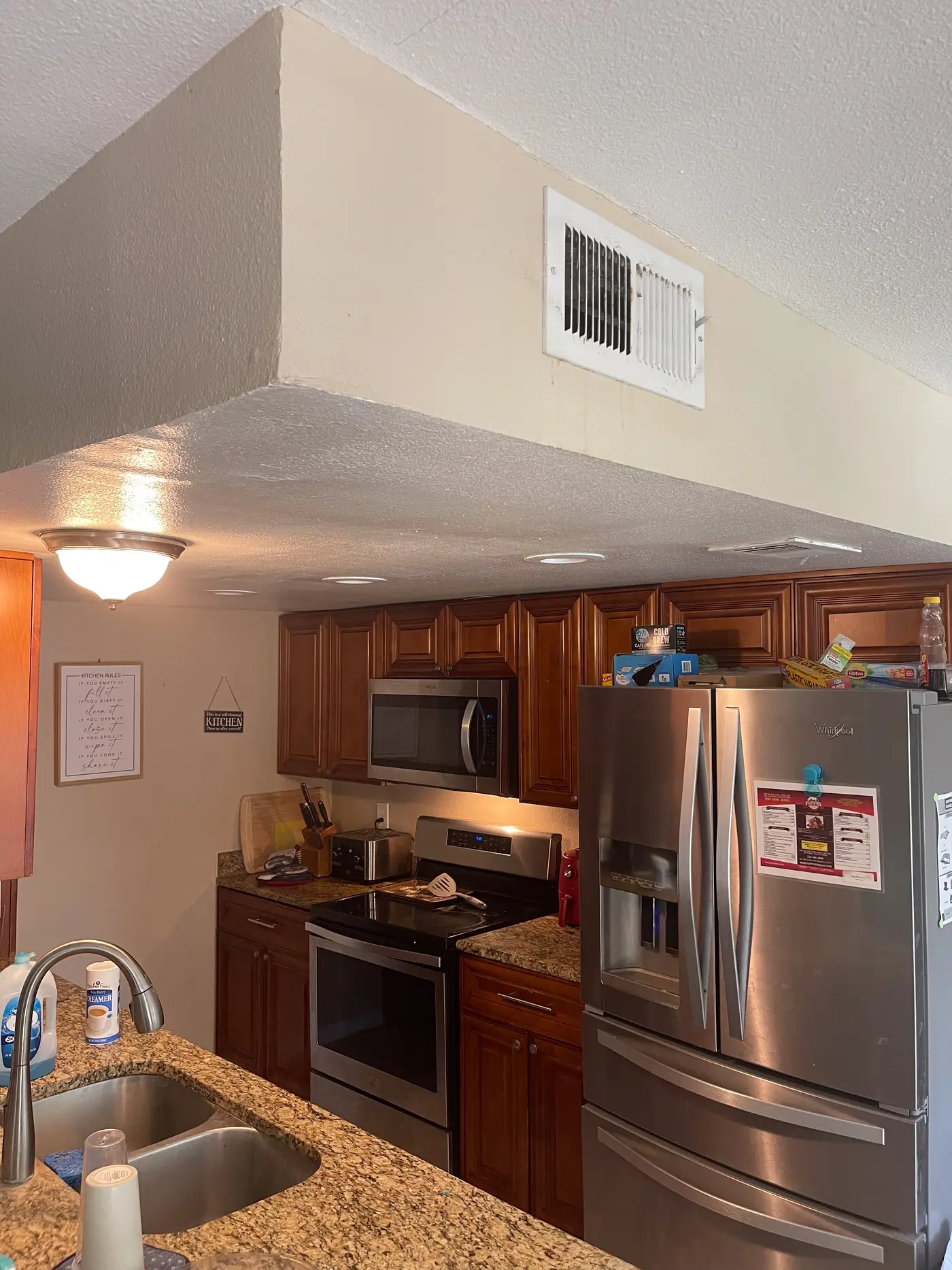 Kitchen with a stainless refrigerator, range and granite counters.