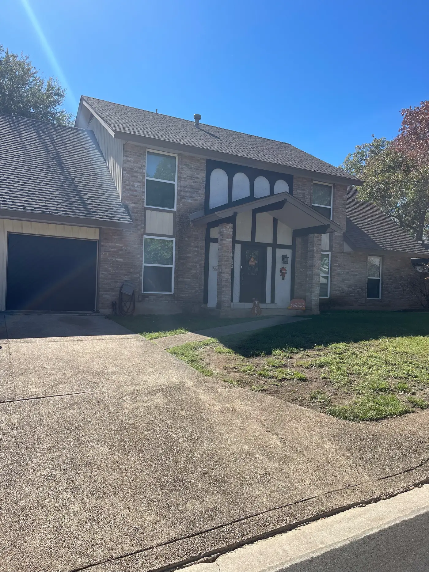 Front of the two-story brick house with the driveway and garage.