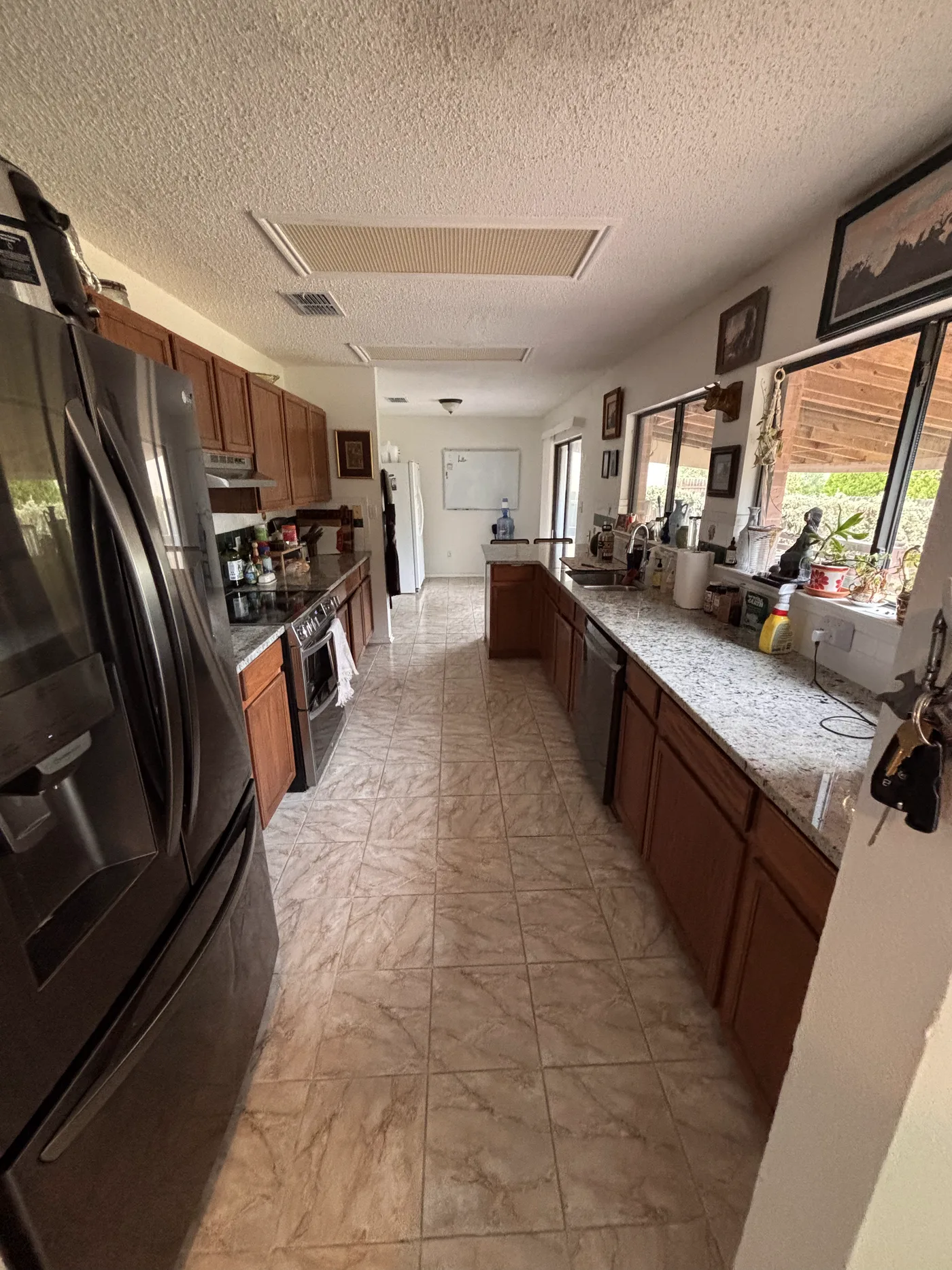 Galley kitchen with granite counters, a stainless range and a window above the sink.