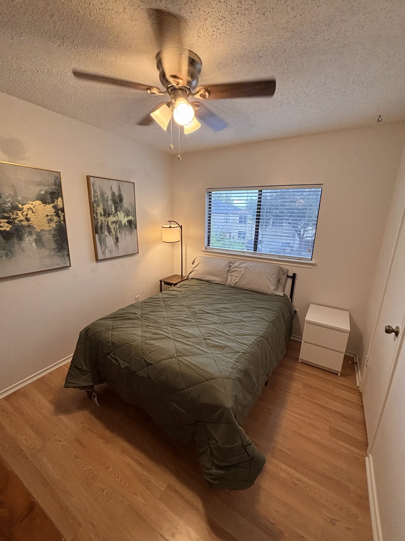 Single room with a full-size bed under a ceiling fan beside the window.