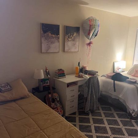 Shared bedroom in Austin sober living home with two beds, desk workspace, and cozy decor