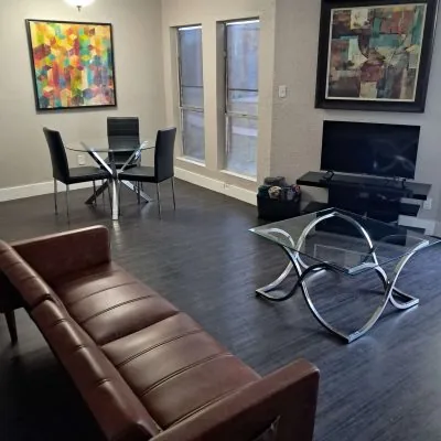 Two-man suite sober apartment in Austin with leather sofa, dining area, and modern furnishings