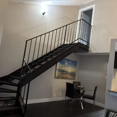 Two-bedroom men’s sober living apartment in Austin with loft-style staircase and dining area