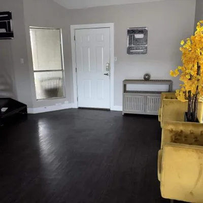 Austin men’s sober apartment living room with TV, couch, and dining area