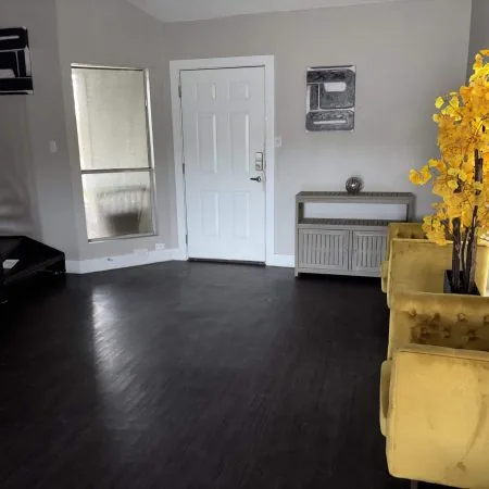 Austin men’s sober apartment living room with TV, couch, and dining area