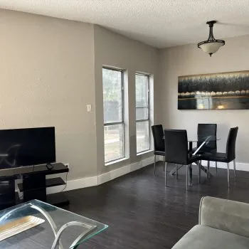 Affordable shared living area in Austin men’s sober apartment with sofa and TV