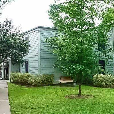 Modern men’s sober living apartment exterior with green landscaping at Eudaimonia Recovery Homes in Austin.